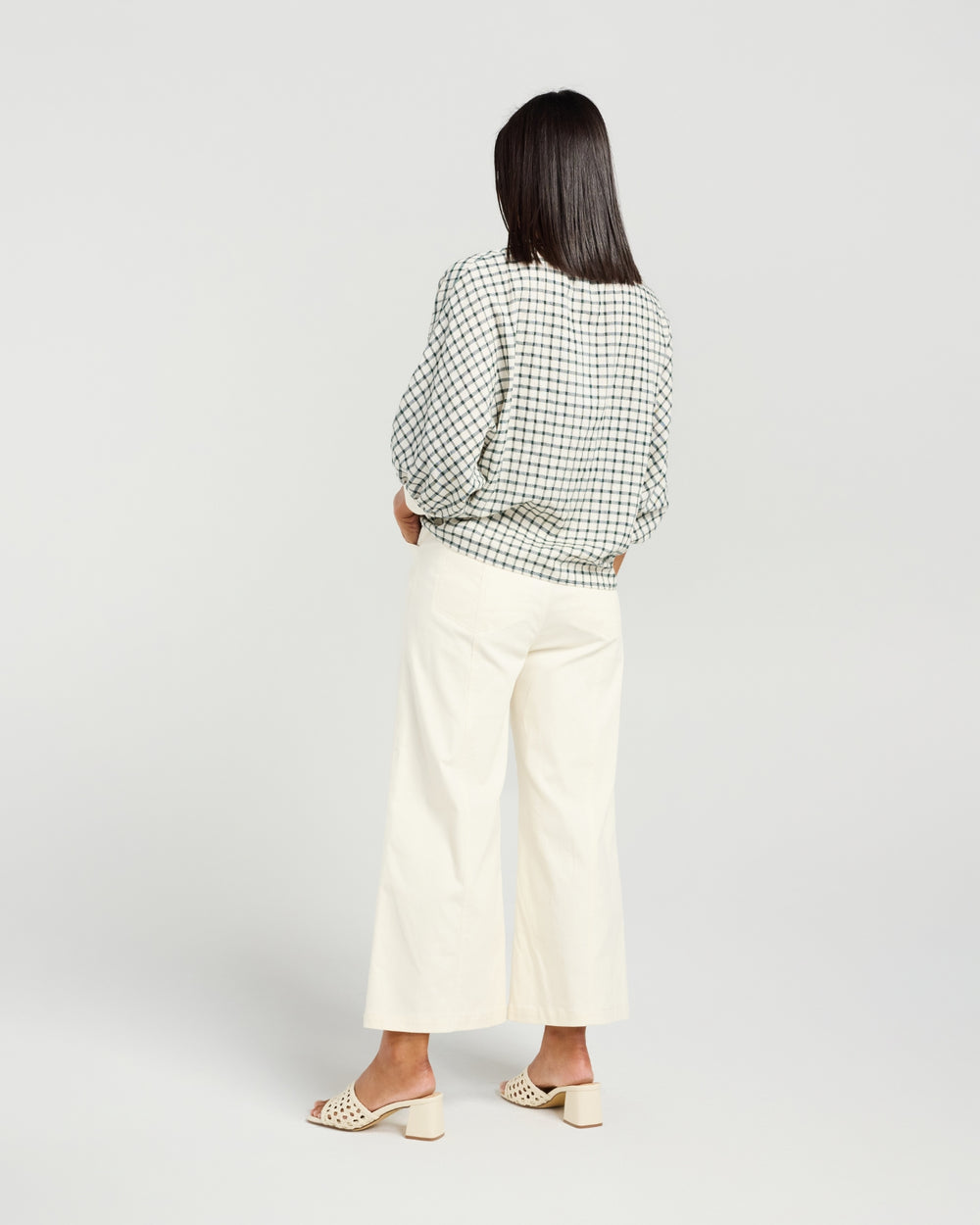 Back view of Kiwi Country Aroha Top in Pine Check paired with off-white wide-leg pants.