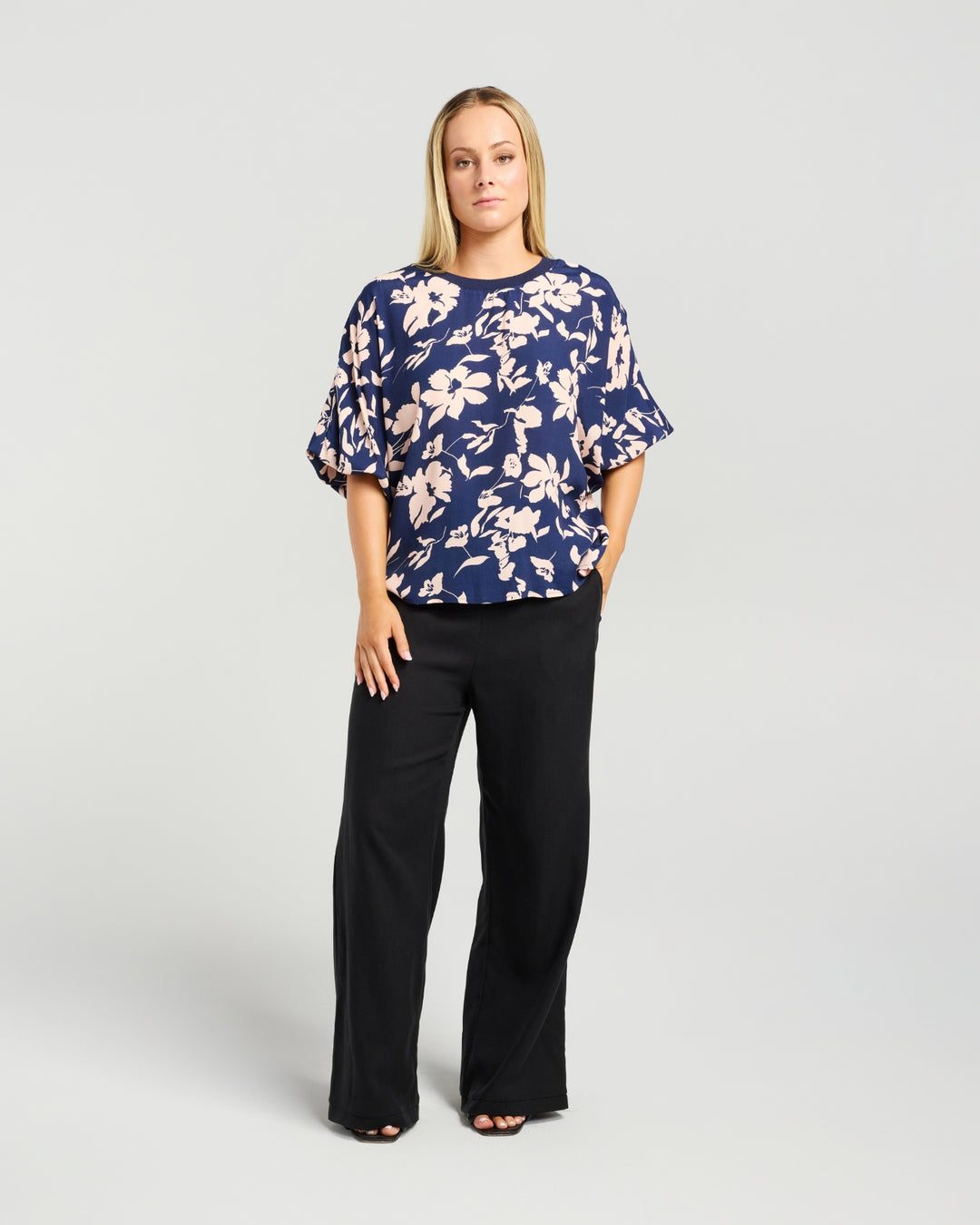 Front view of Kiwi Country Aroha Top in Indigo Blush paired with black pants.