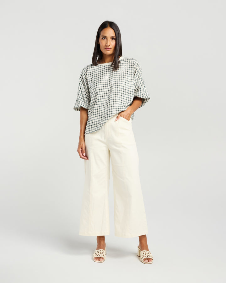Front view of Kiwi Country Aroha Top in Pine Check paired with off-white wide-leg pants.